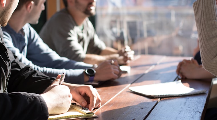 A team working through notes around a wooden table